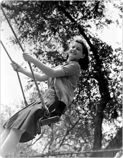 A girl enjoys her local park?s swing.