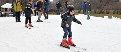 a child skiis down a hill covered in snow