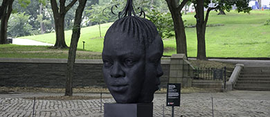 A sculpture of faces on a plaza