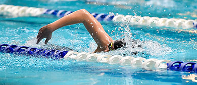 An individual swims laps in an indoor pool