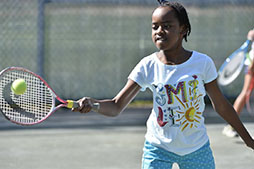 a kid plays tennis
