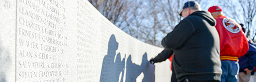 war veterans look for names of fallen soldiers on a wall of the granite memorial