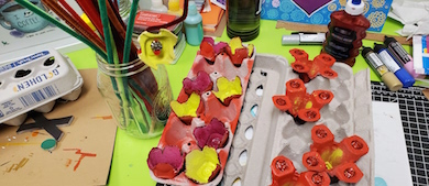 art supplies including paint, old egg cartons, paint brushes