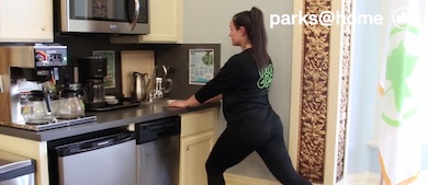 an instructor uses holding on to a kitchen's sink edge to perform a lunch by bending her knees. Text overlayed on the image reads Parks at Home