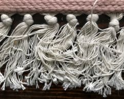 A close-up photo of the tassels of an area rug.