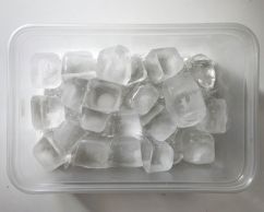 A photo of ice cubes framed inside a clear container.