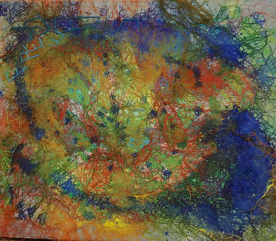 threads in various colors embroiderd on a canvas; there are blotches of blue, green, red, and yellow. The word free is embroiderd in blue at the top left of the canvas