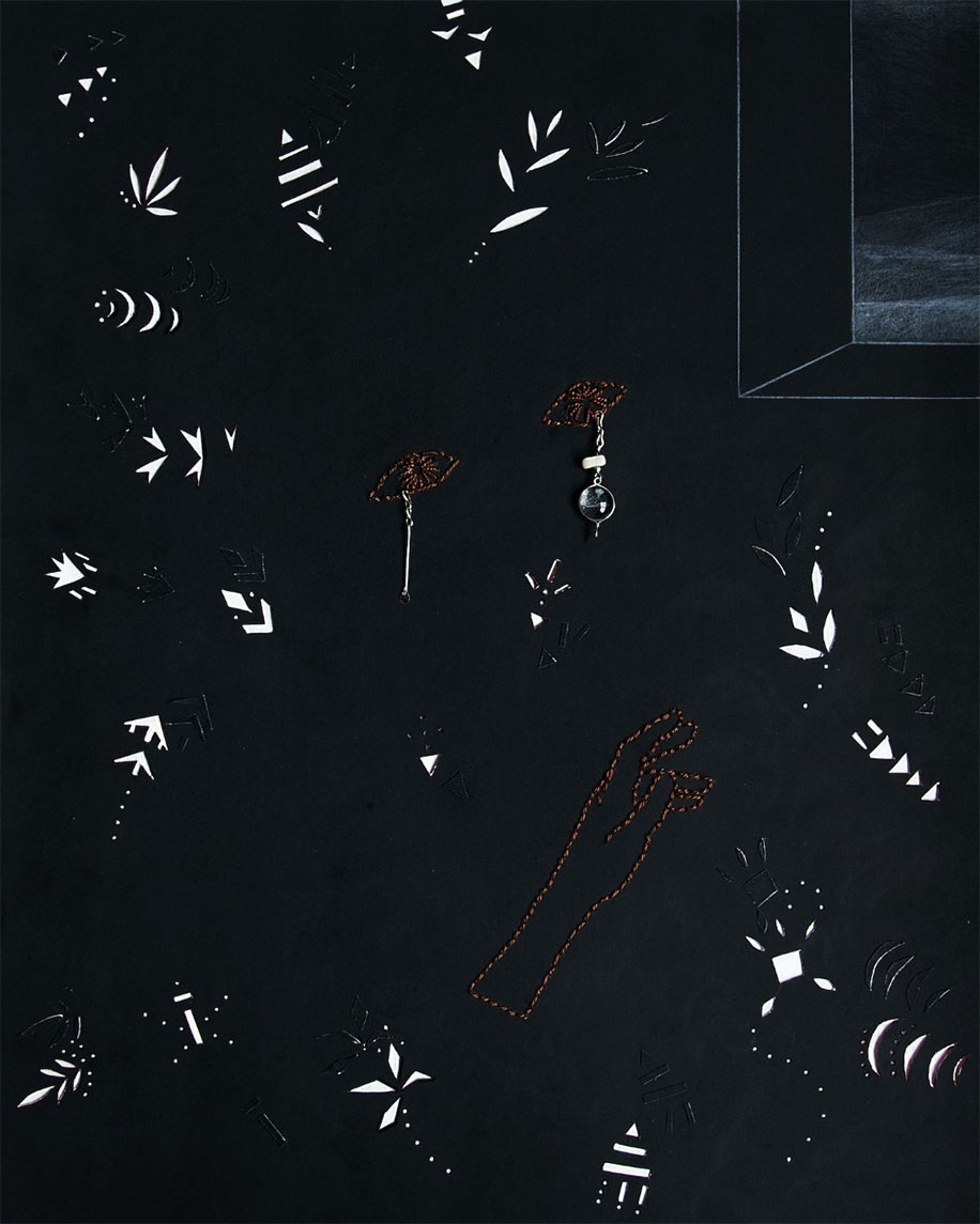 white patterns of arrows, leaves, and other figurines agains a black wall next to a window like structure that looks out to darkness. Eye-like drawings and a hand is embroidered on the background in brown thread