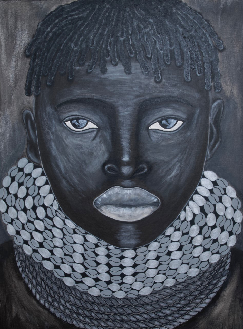 portrait of a boy with piercing eyes wearing a traditional necklace