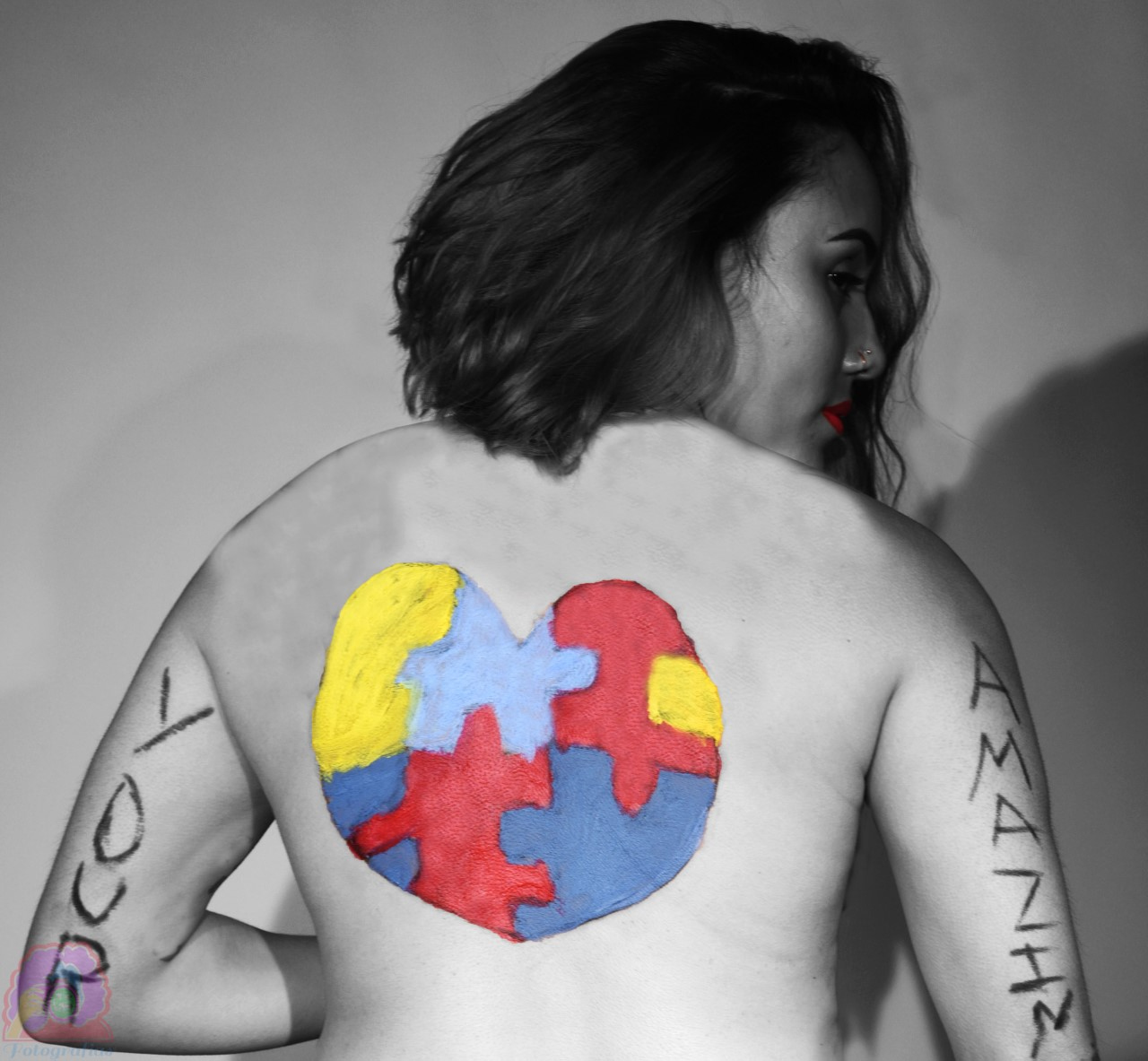 A heart made of puzzle pieces is drawn on the back of the model, the words "your" is written on the left arm and the word "amazin" is written on the right arm.