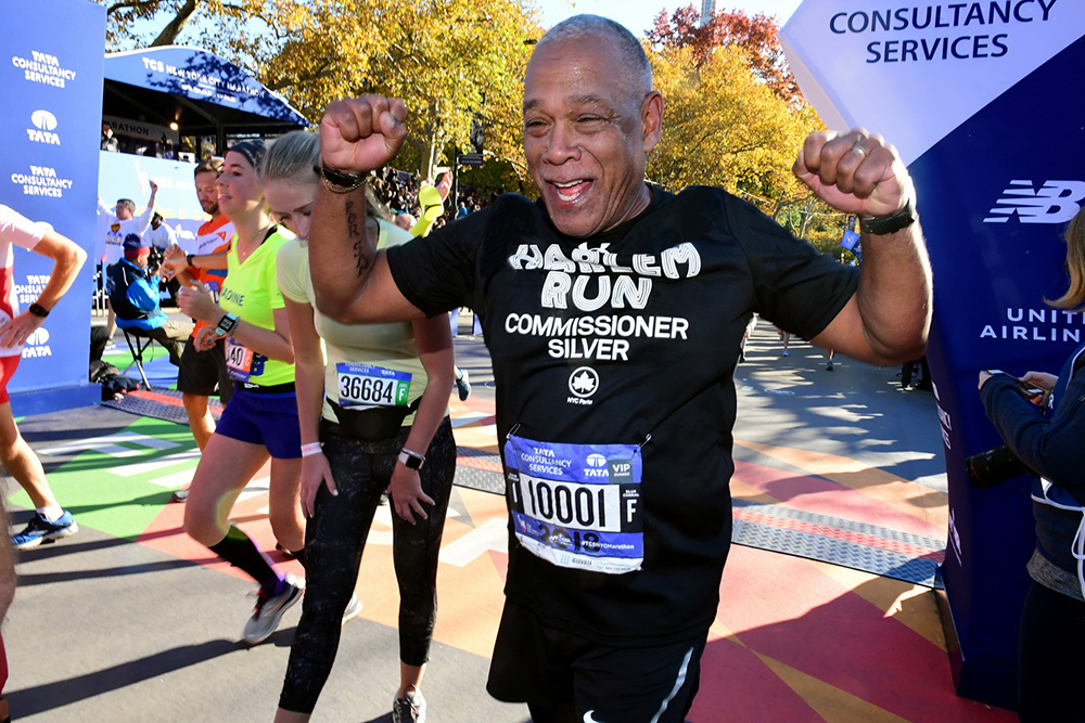 Parks Commissioner Mitchell J. Silver raises his fists in the air as he crosses the finish line