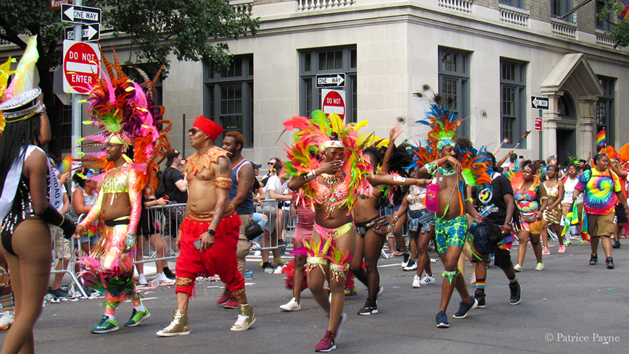 Pride Parade participants in carnival costume make their way through the parade