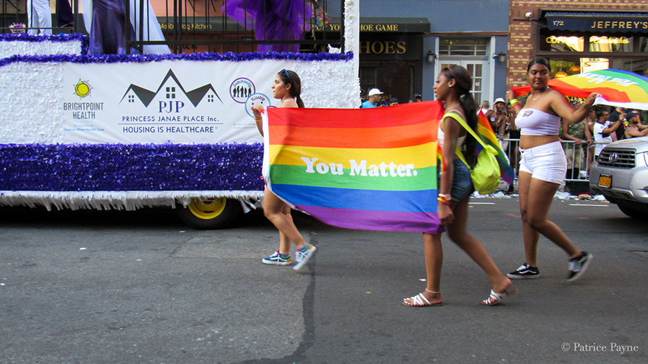 Parade participants hold up a Pride flag with the words You Matter