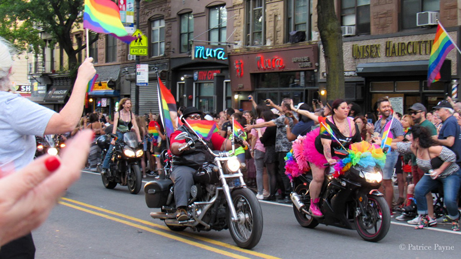 Parade participants ride through the parade on motorbikes dressed up in Pride colors